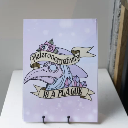 photo of an art print that reads "heteronormativity is a plague" on a banner over a pastel plague doctor mask.