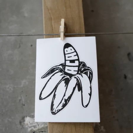 Close up of BACAB sticker a black and white half peeled banana that has ACAB in bold white text on the peeled portion.