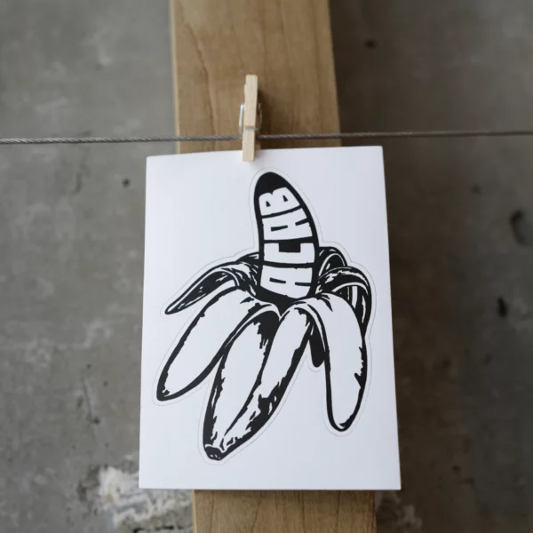 Close up of BACAB sticker a black and white half peeled banana that has ACAB in bold white text on the peeled portion.